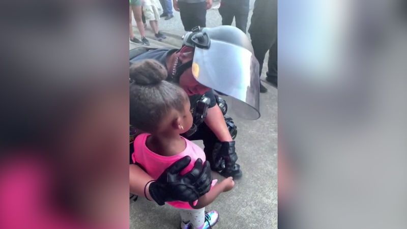 Policista během demonstrací utěšoval malou holčičku